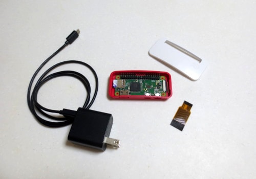 Raspberry Pi Zero WH本体、電源ケーブル、ケース、カメラケーブルを並べた写真